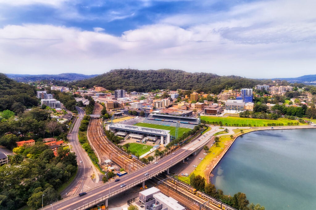 Gosford, Australia, showcasing the Central Coast Stadium, railway lines, and the waterfront of Brisbane Water.