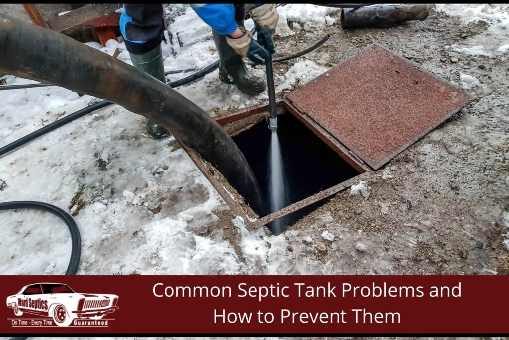 A worker spraying a high-pressure water stream down into an open septic tank hatch while a large vacuum hose pumps out waste on a snowy ground.