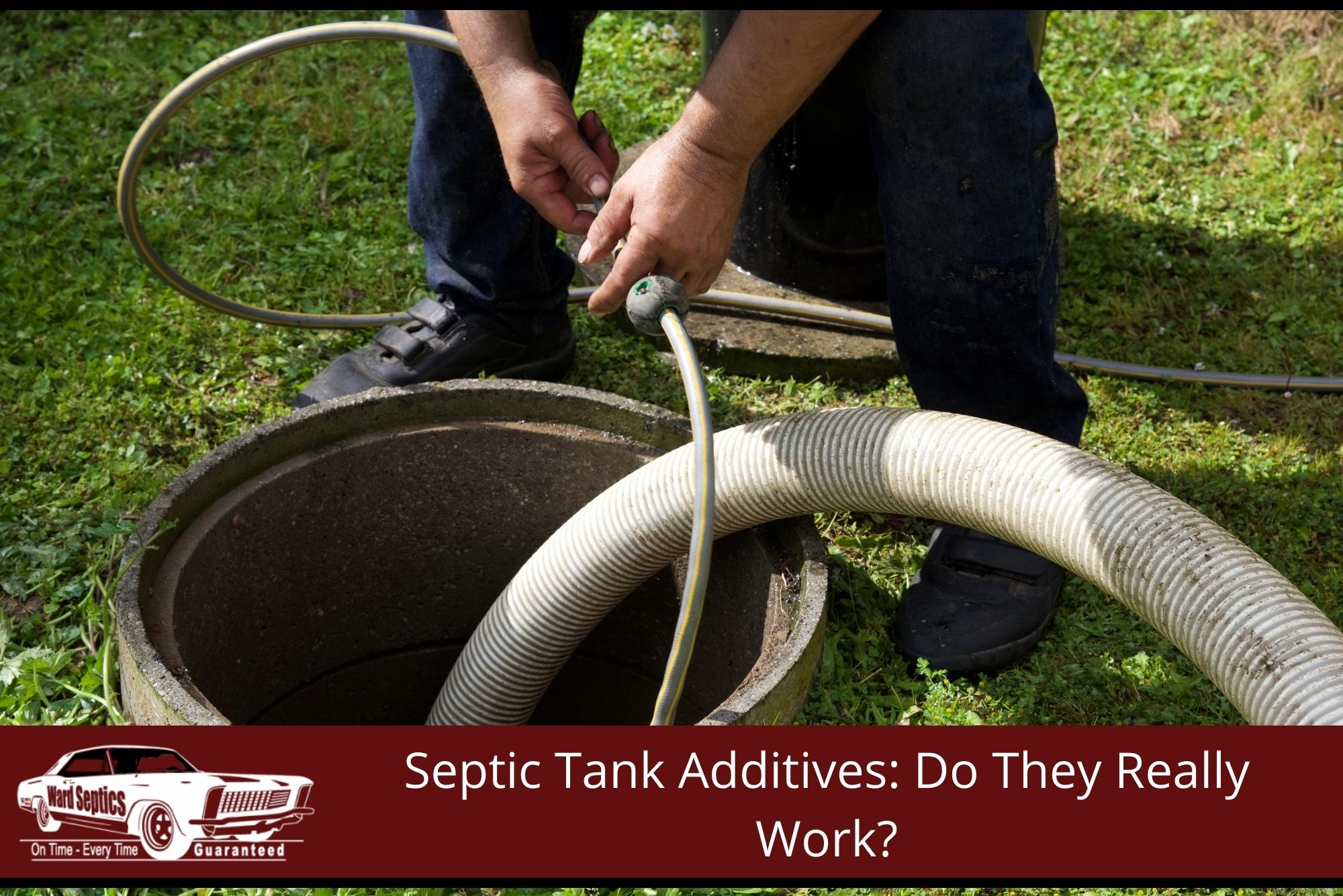 A small yellow line next to a large corrugated suction hose lowered into an open concrete septic tank manhole.