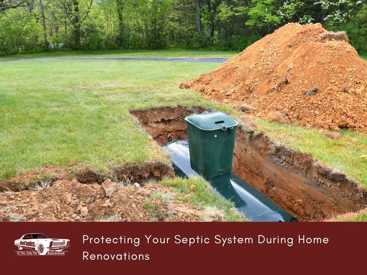 A green plastic septic tank is installed in a dirt trench in a lawn next to a pile of excavated soil.