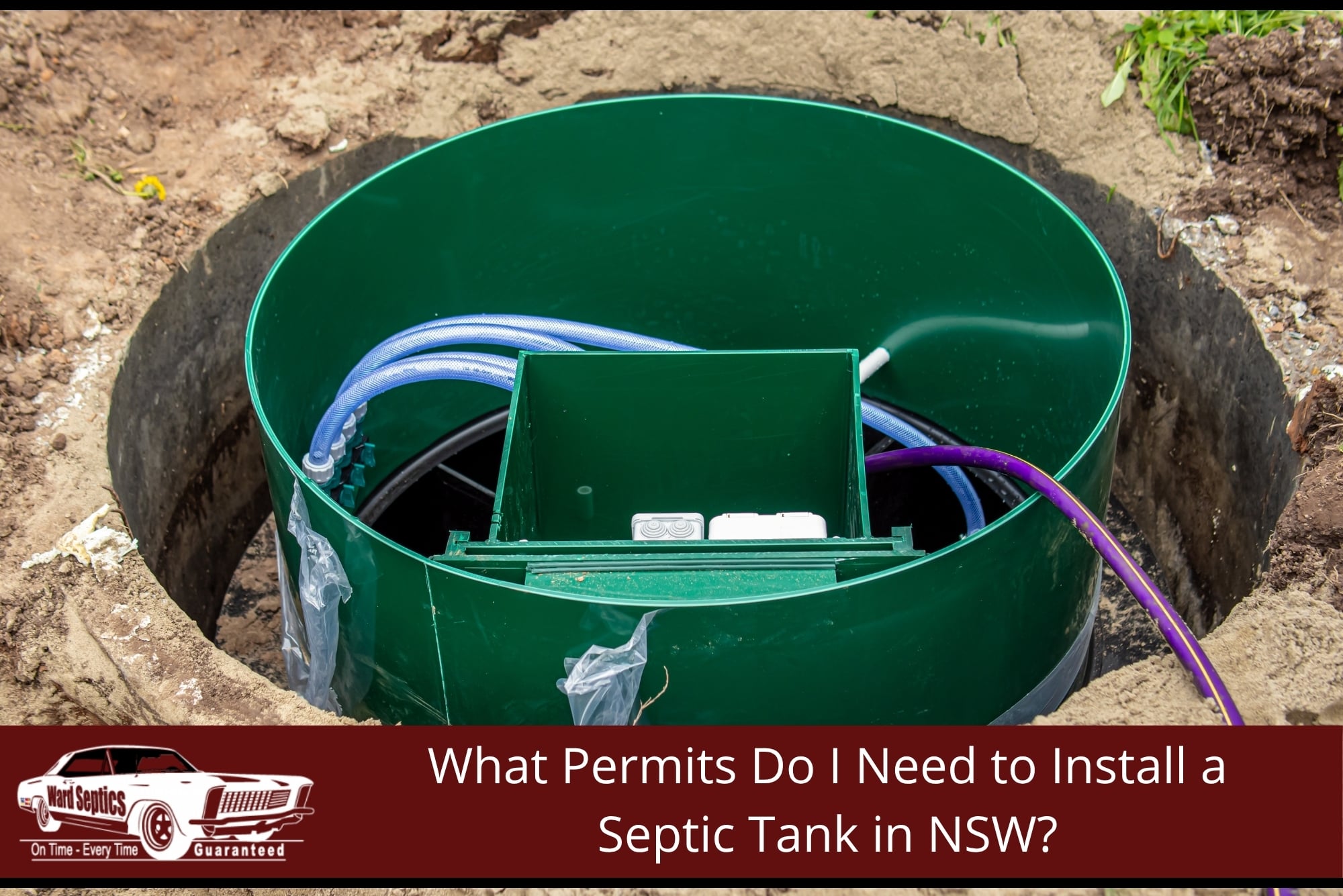 A large green cylindrical septic tank riser installed in a dirt pit, showing internal wiring, a plastic manifold box, and purple and blue plumbing lines.