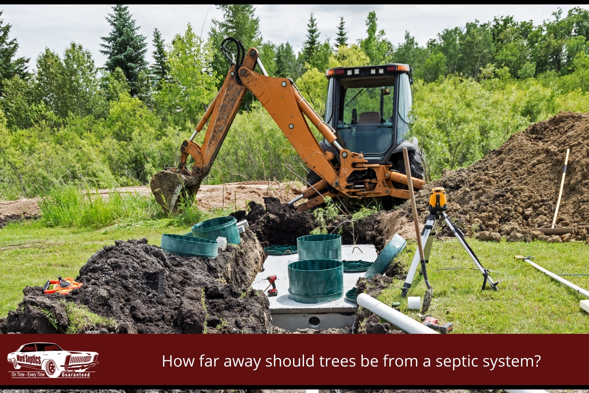 An orange excavator working on a septic system installation in a wooded area