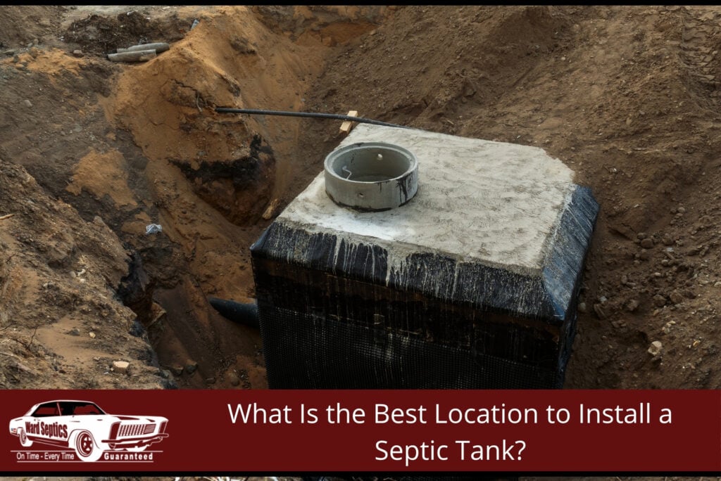 A newly installed concrete septic tank sits in a deep dirt excavation pit with connected piping