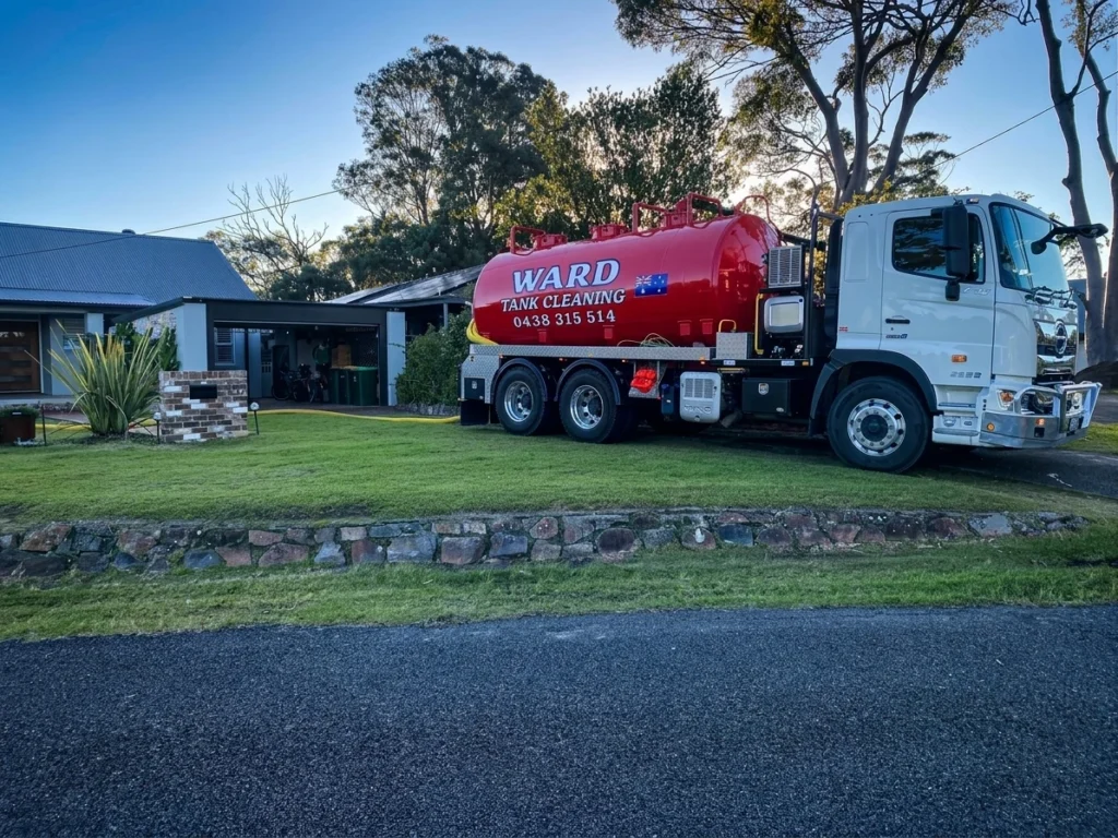 Red Ward Tank Cleaning truck parked in front of a residential property.